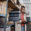 Man in a nifty coat using Pro2 camera to scan some shelves in a warehouse